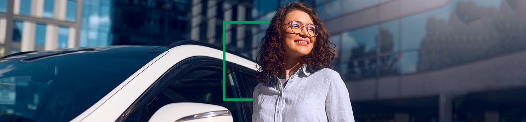 Immagine fotografica di una donna sorridente accanto a una autovettura